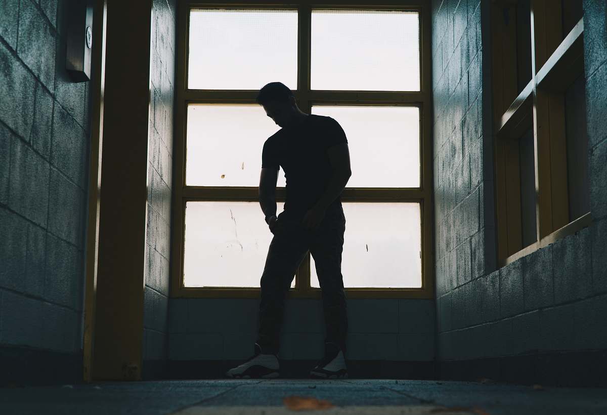 people silhouette photo of a man standing near glass window human