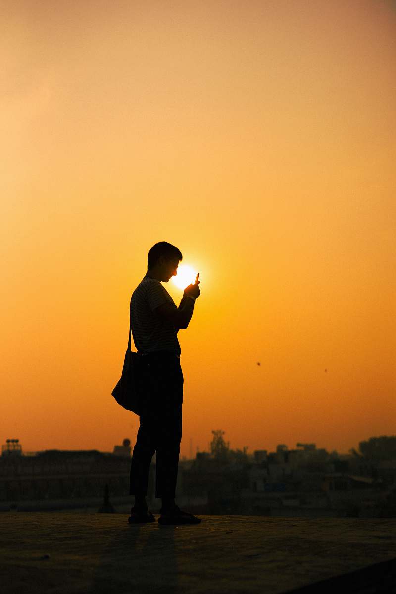 nature silhouette photo of man with bag sunlight