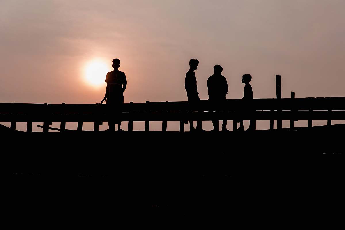 water silhouette photography of four people waterfront
