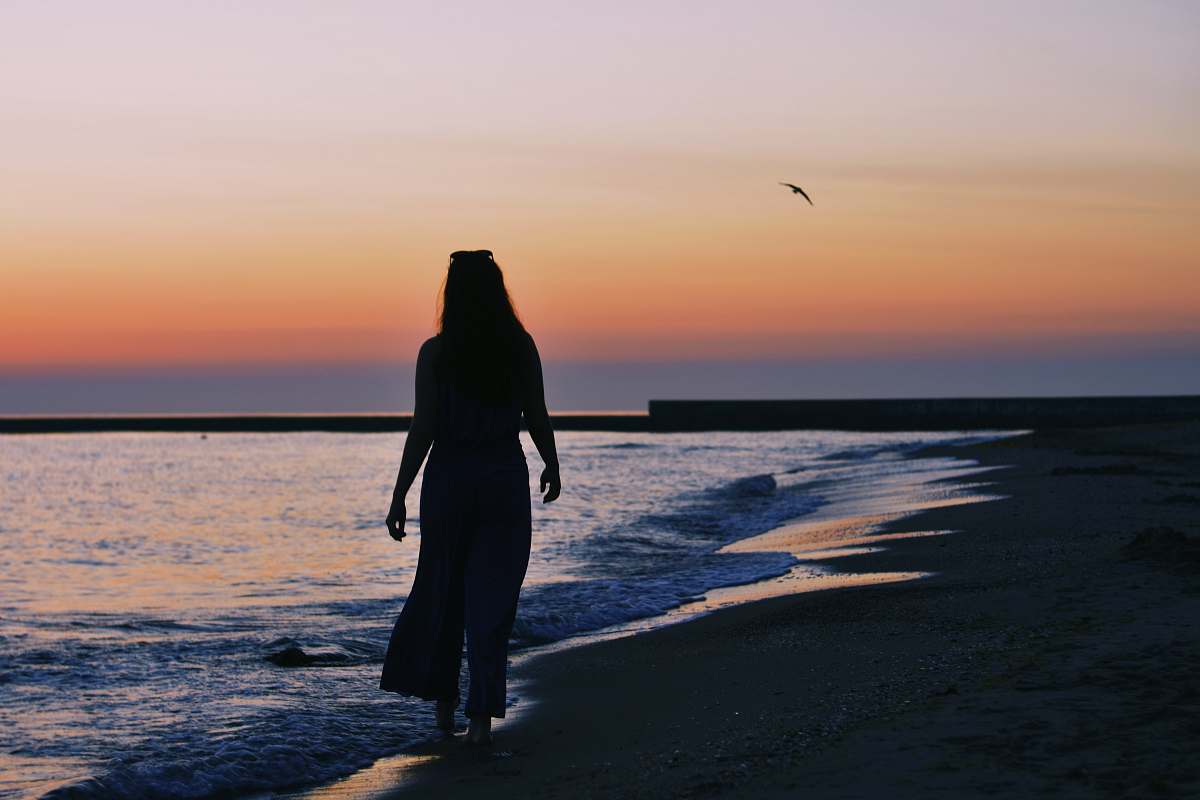 human woman silhouette on beach shore during golden hour people
