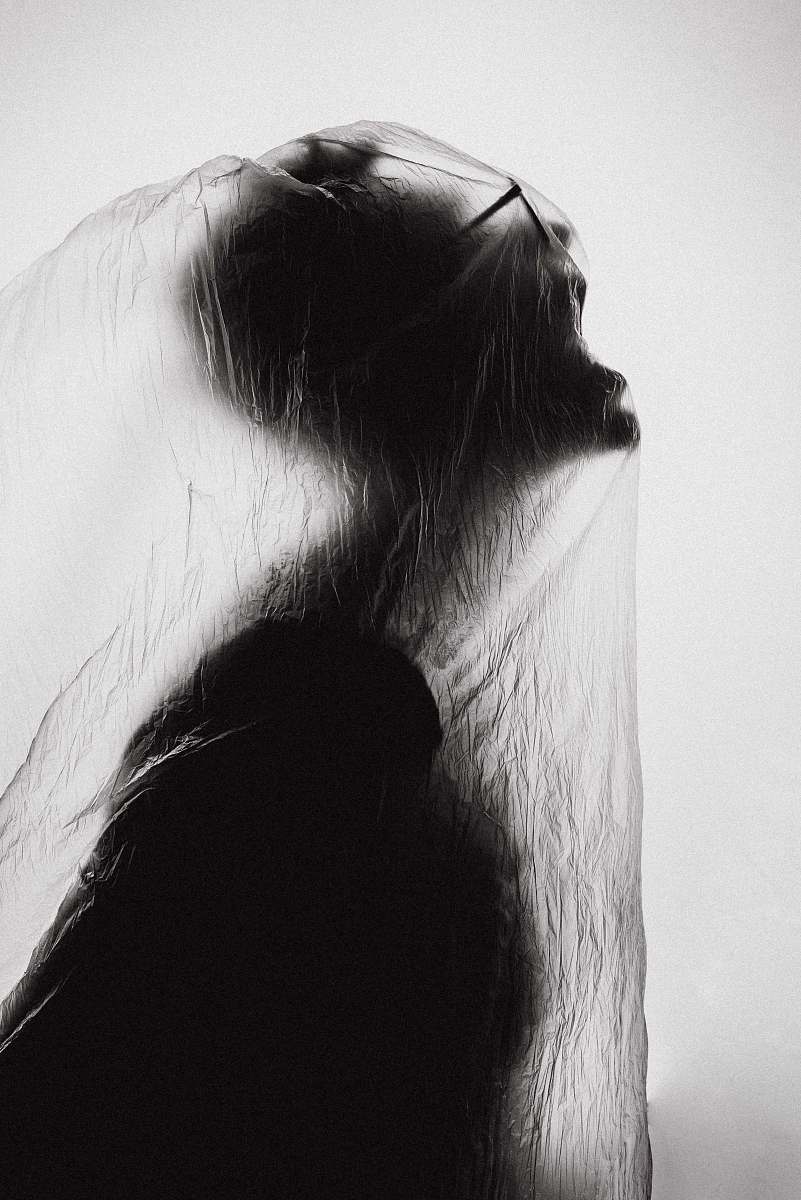 black macro photography of person wrapped with clear plastic bag halloween
