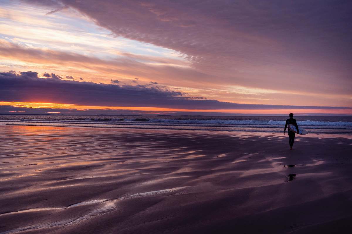 person person standing on coastline under cloudy sky walking