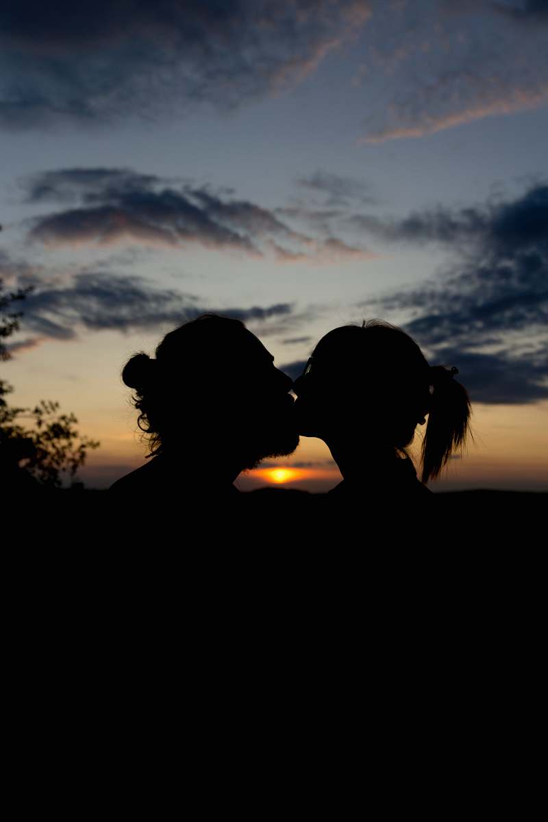 nature man and woman kissing during golden hour human