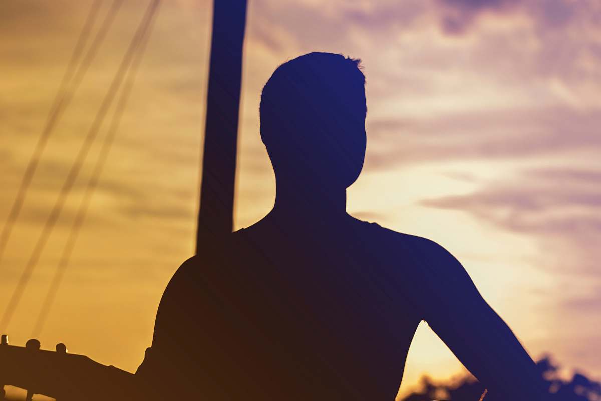 sunset man in front of post during day back
