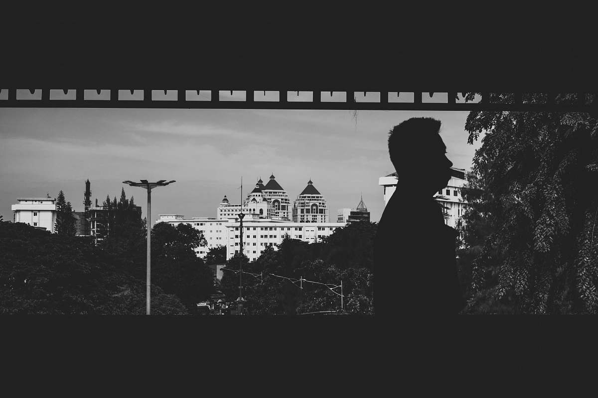 black-and-white man standing near building grey