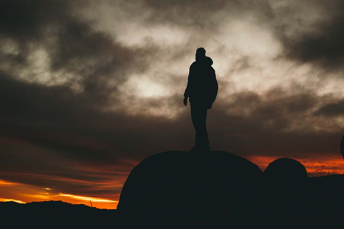 standing man standing on rock during golden hour nature