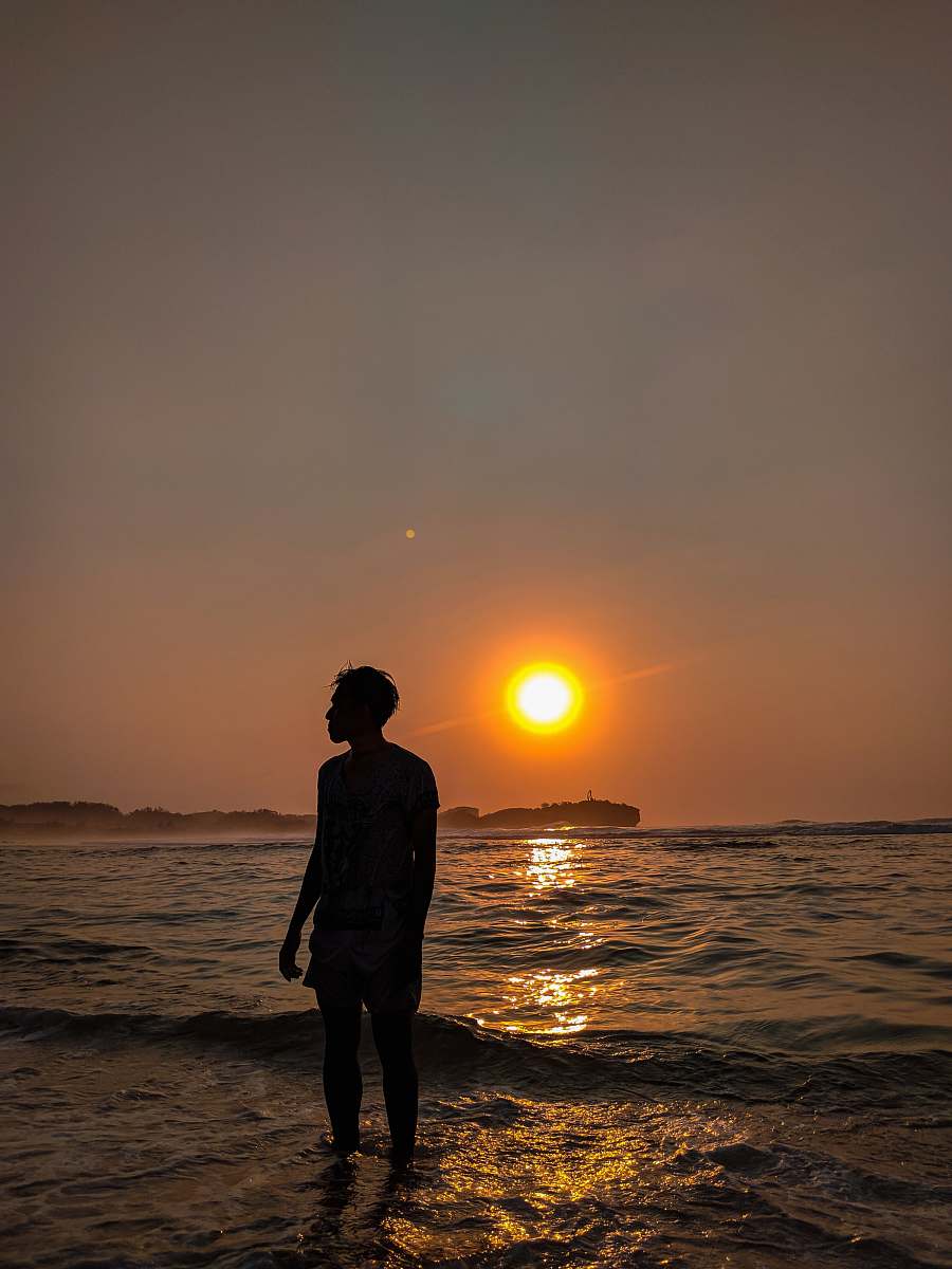 sunset man standing on seashore during sunset nature