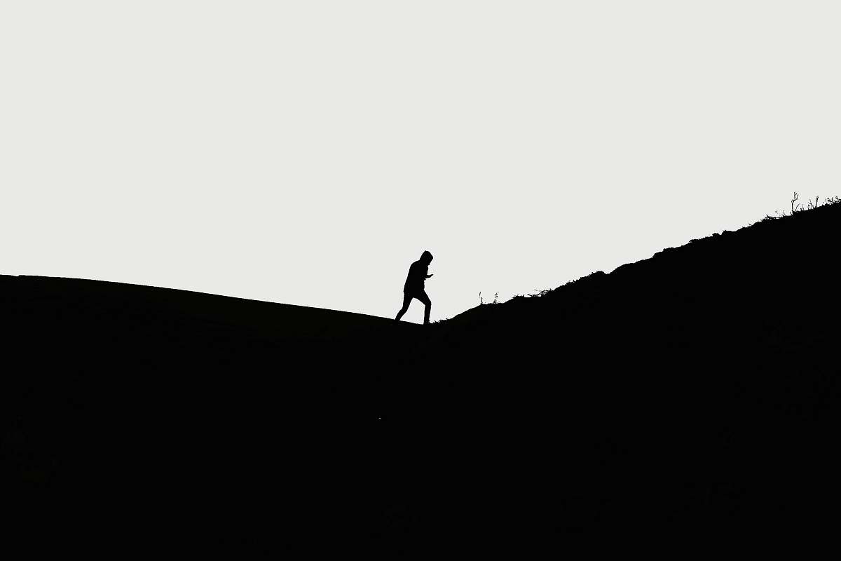 black-and-white man walking on hill standing