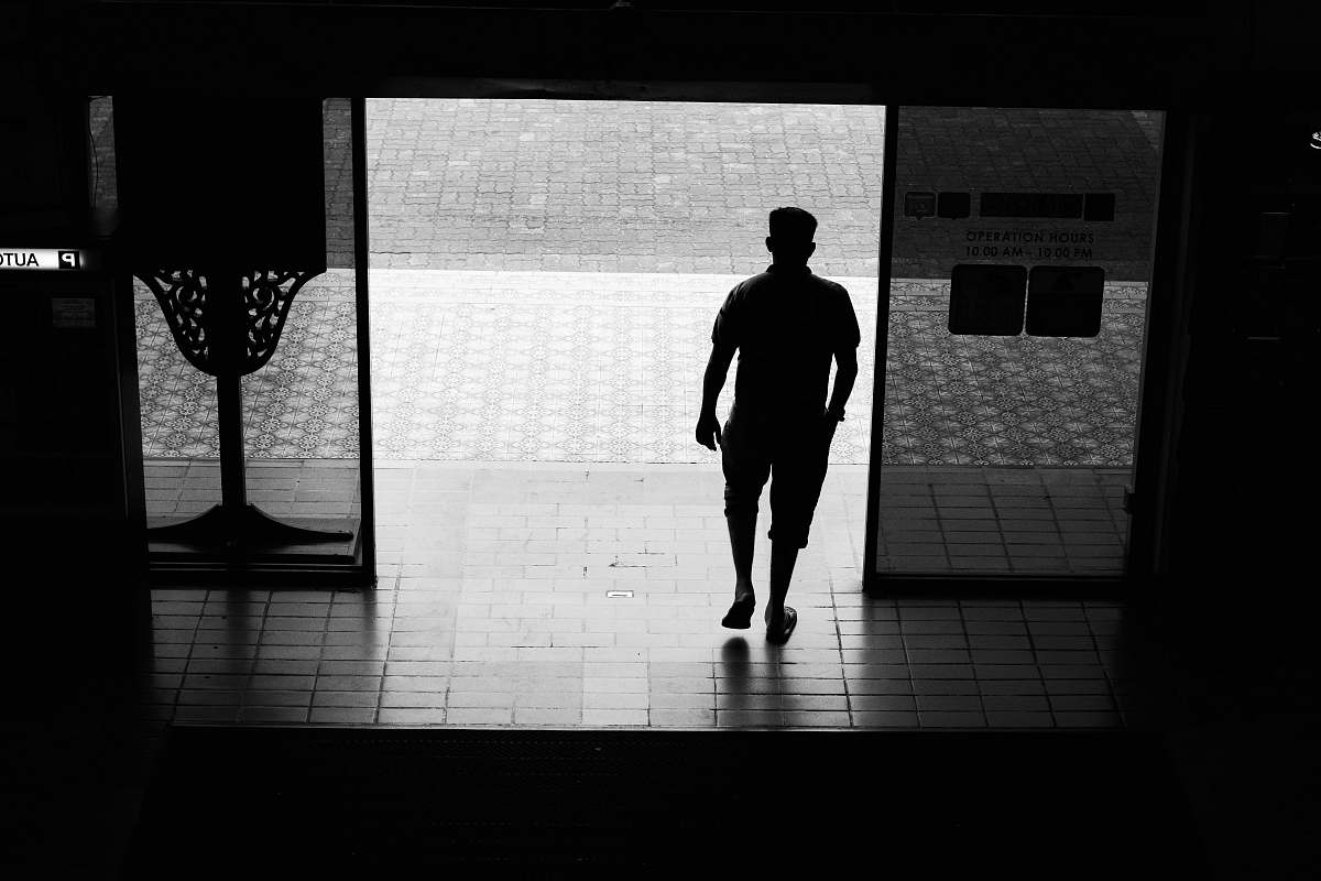 person man walking out of door black-and-white