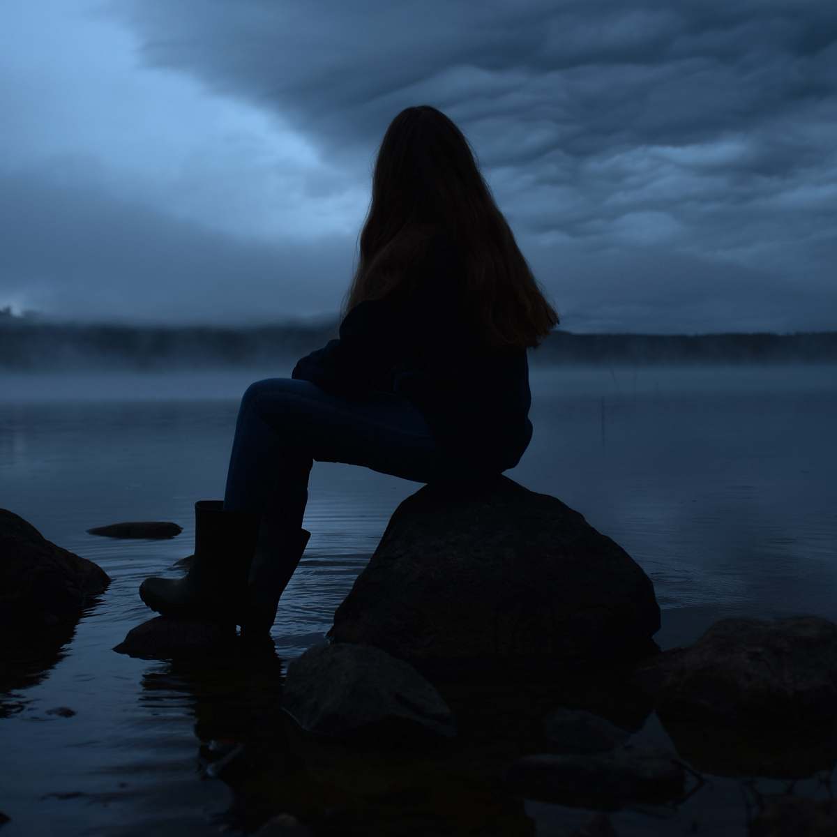 nature person siting on rock outdoors