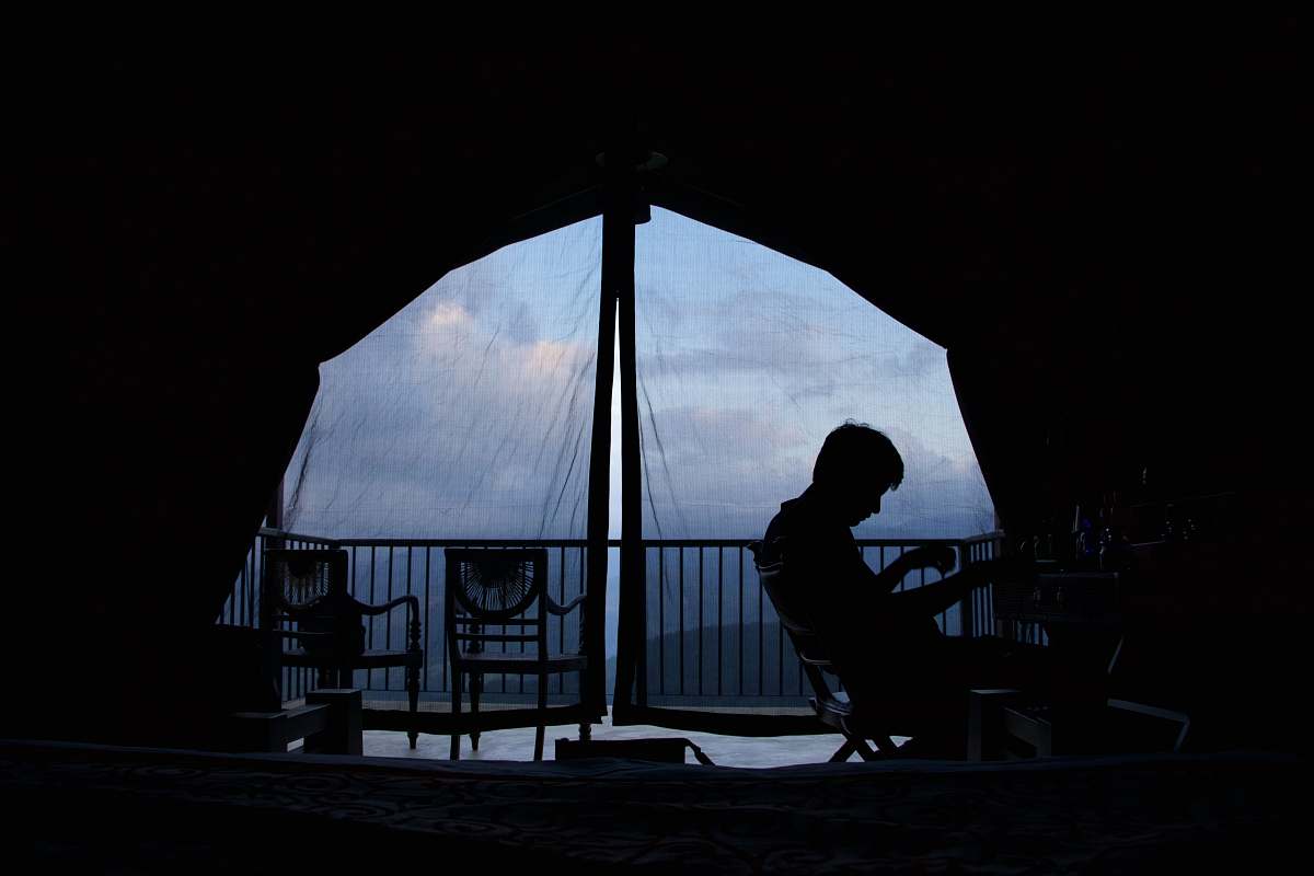 human person sitting on chair inside canopy tent person