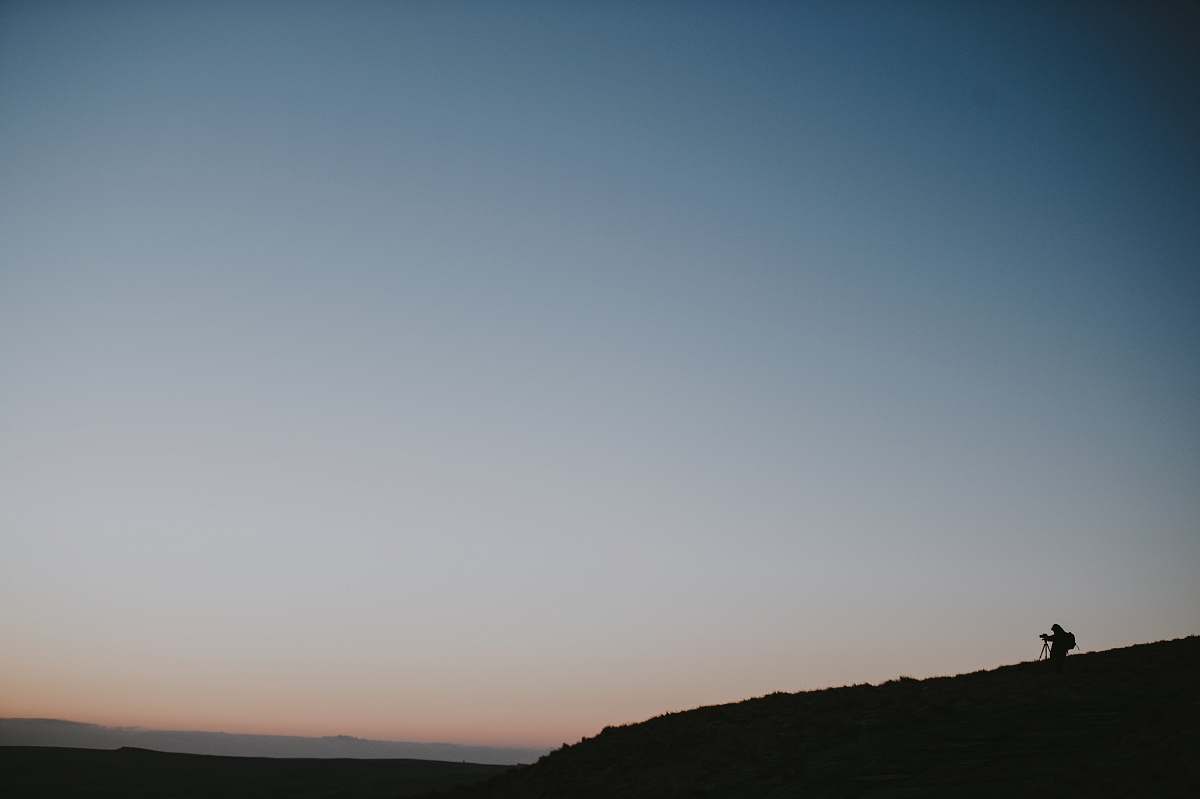 sunrise person standing on hill under blue sky grey