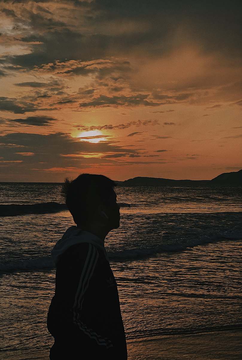nature person standing on shore during golden hour outdoors