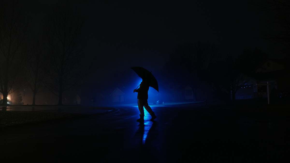 lighting person standing while using umbrella human