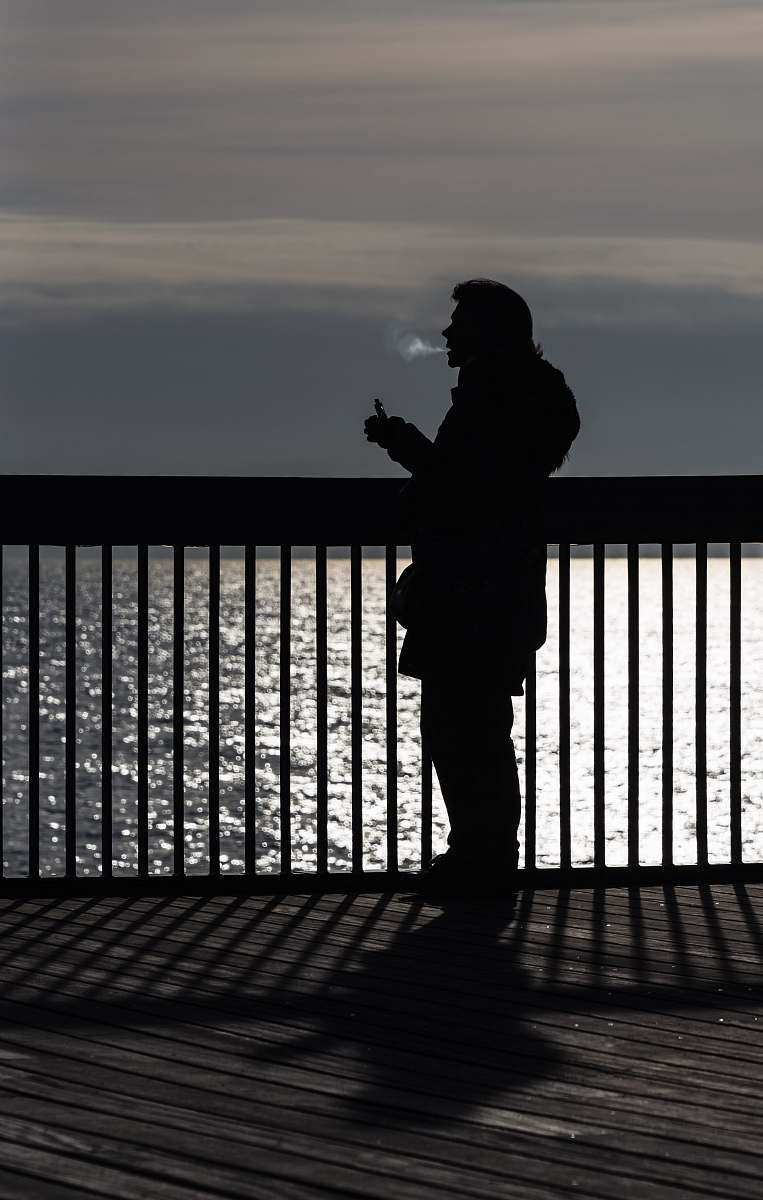 person person using vape near body of water people