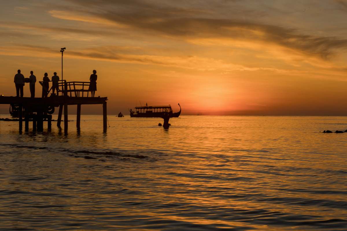 sunset photo of people on sea dock during sunset pier