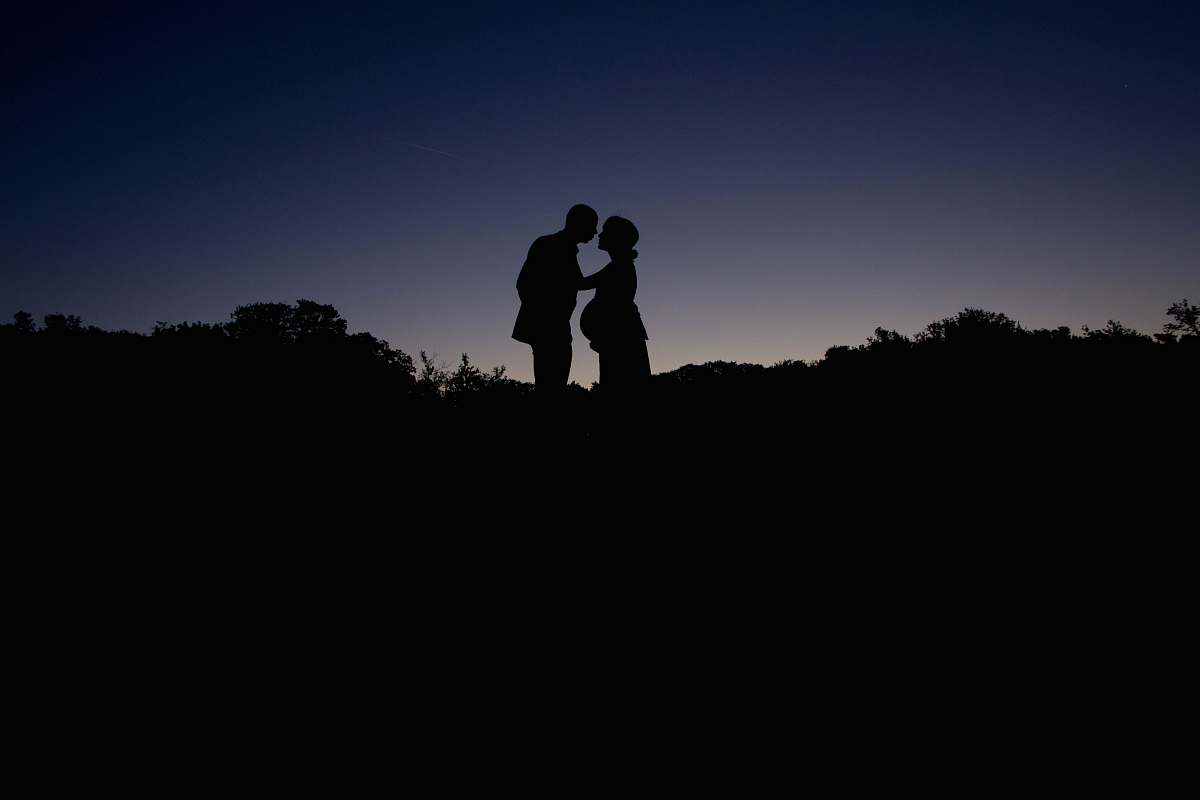 person silhouette couple standing during golden hour human
