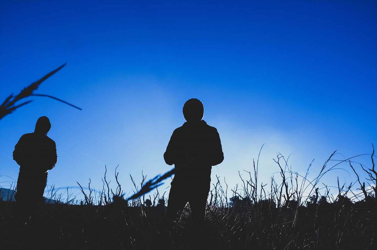 human silhouette of 2 person at field during daytime person