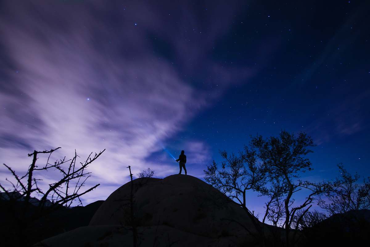 stars silhouette of a person on mountain hill trees