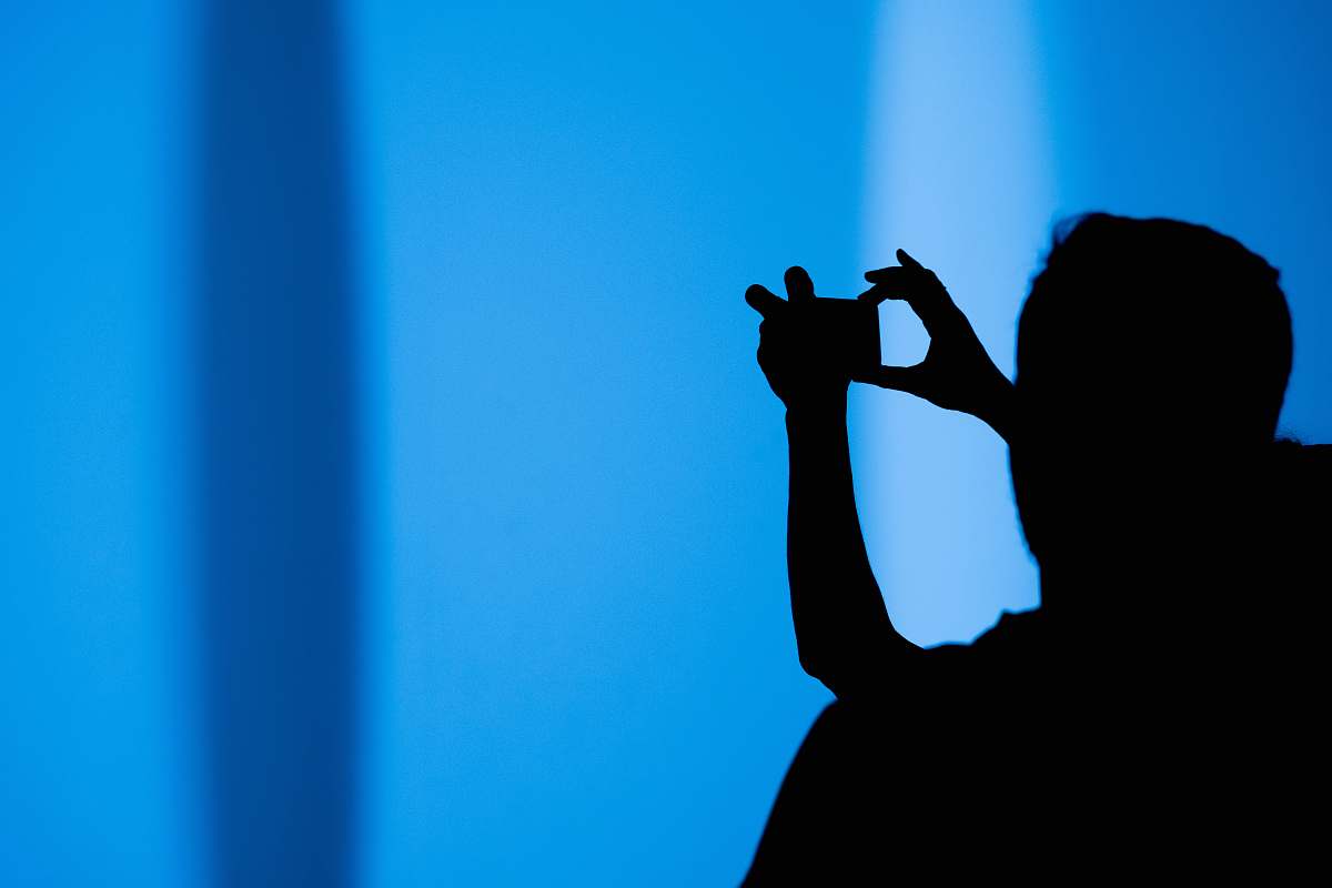 blue silhouette of a person using a gadget tate modern