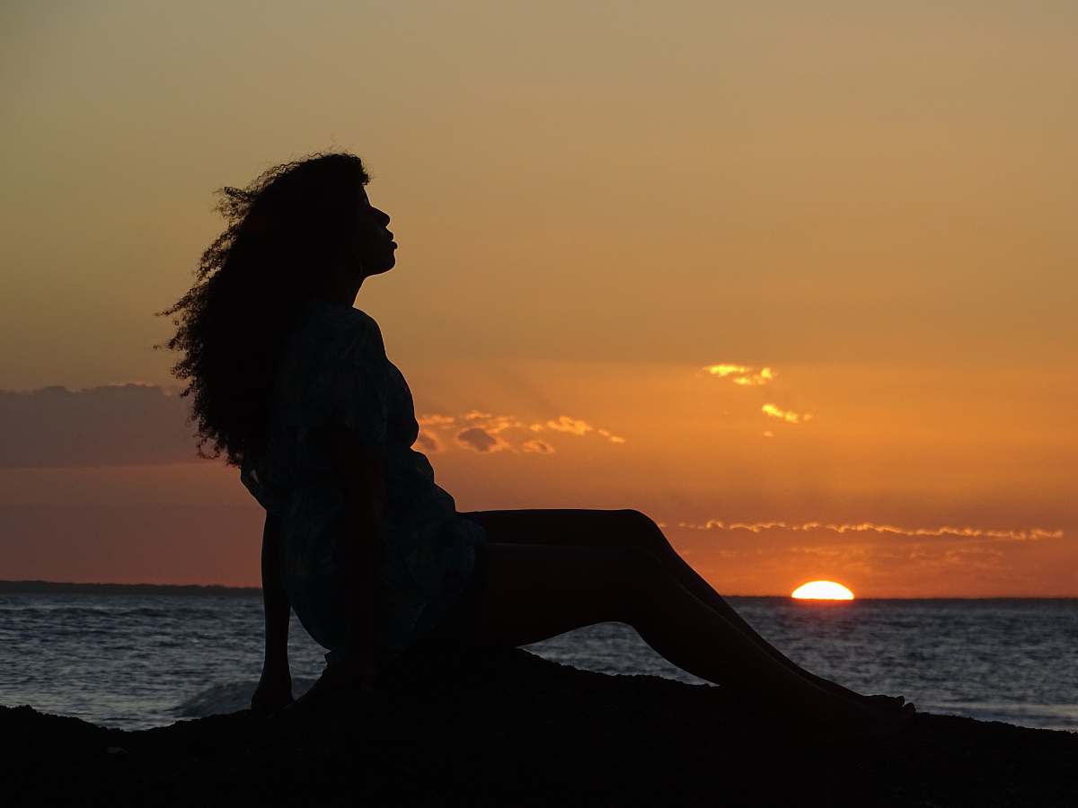 Nature Silhouette Of A Woman Sitting On The Ground During Golden Hour ...