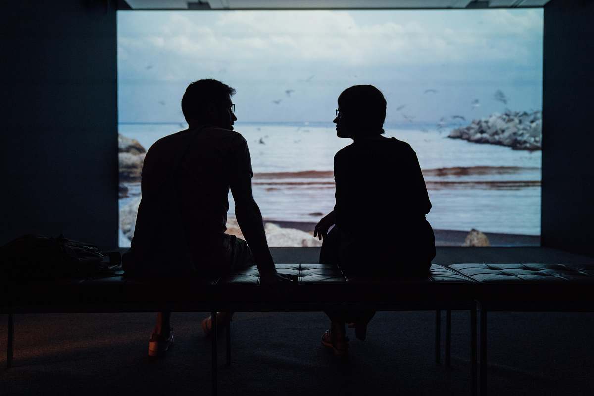 person silhouette of man and woman sitting on ottoman human