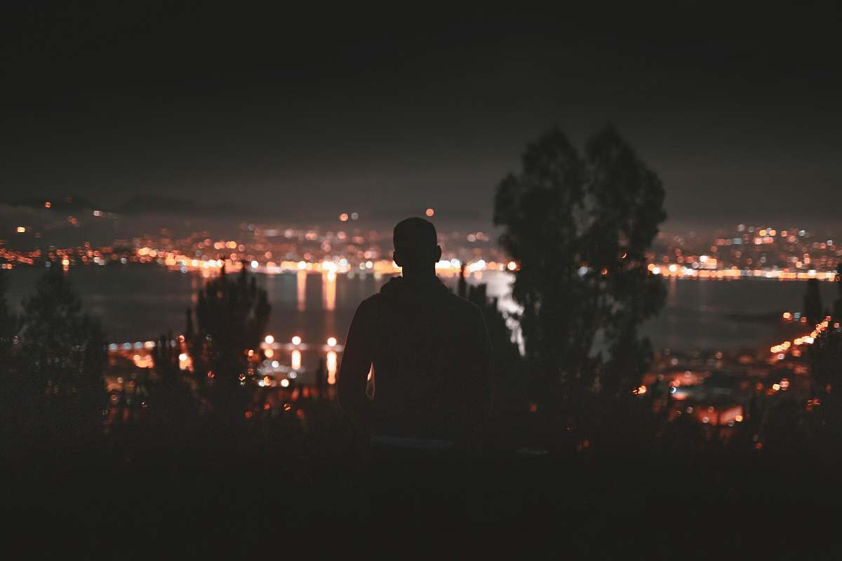 night silhouette of man facing in front of building cangas