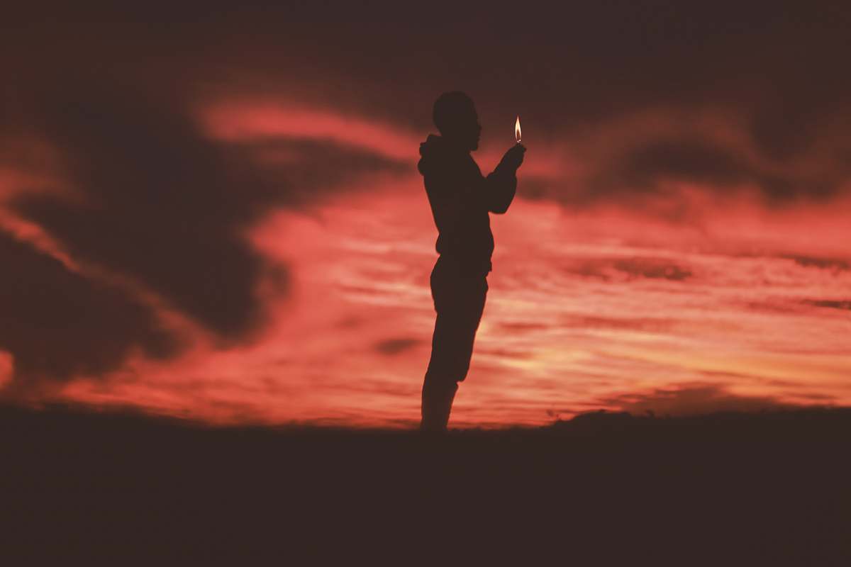 person silhouette of man holding lighter people