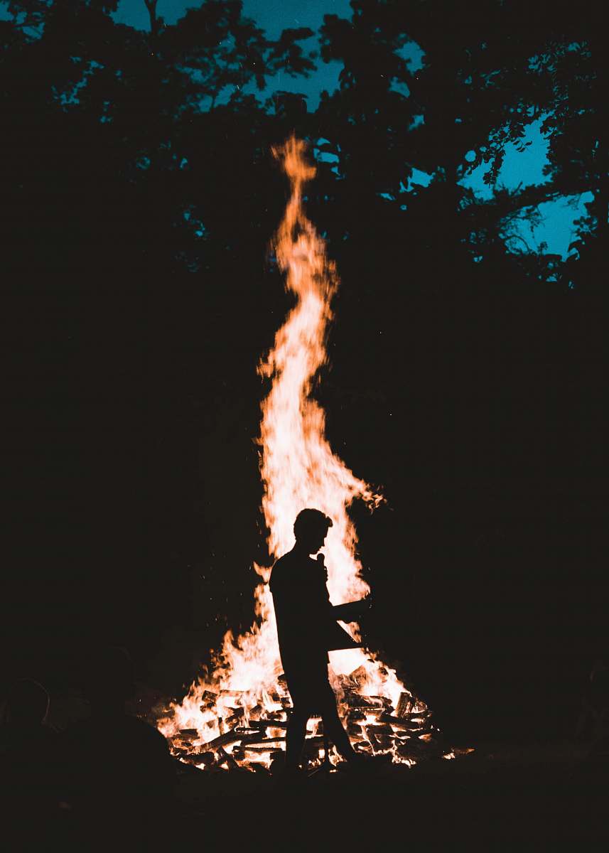 fire silhouette of man in front of bonfire campfire