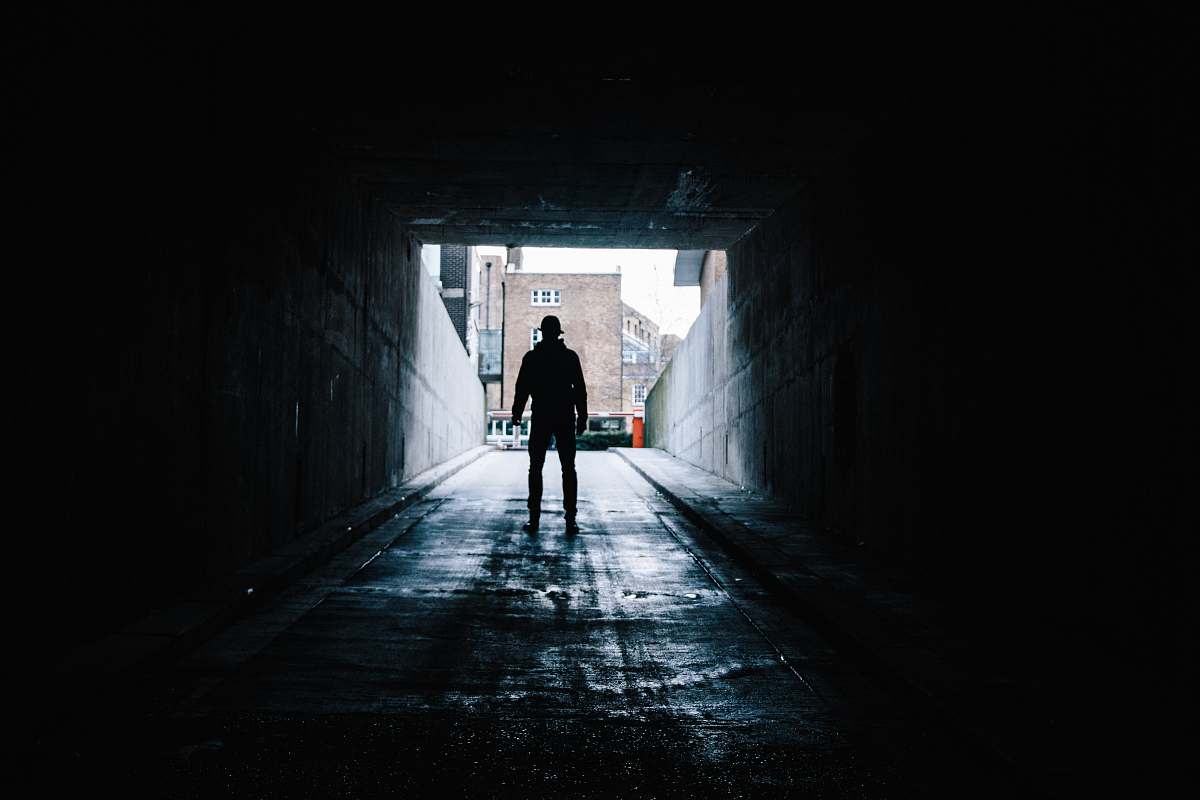 tunnel silhouette of man in underground garage dark