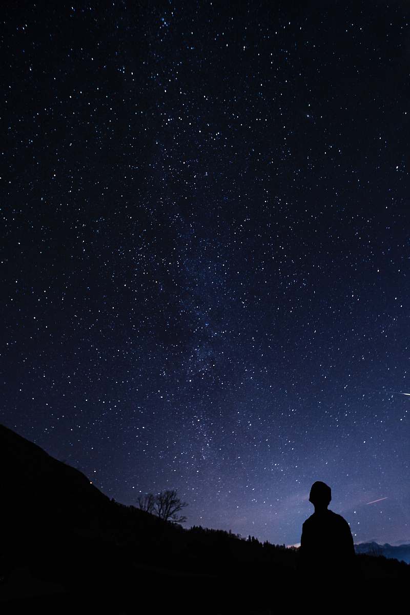 person silhouette of man looking at milky way space