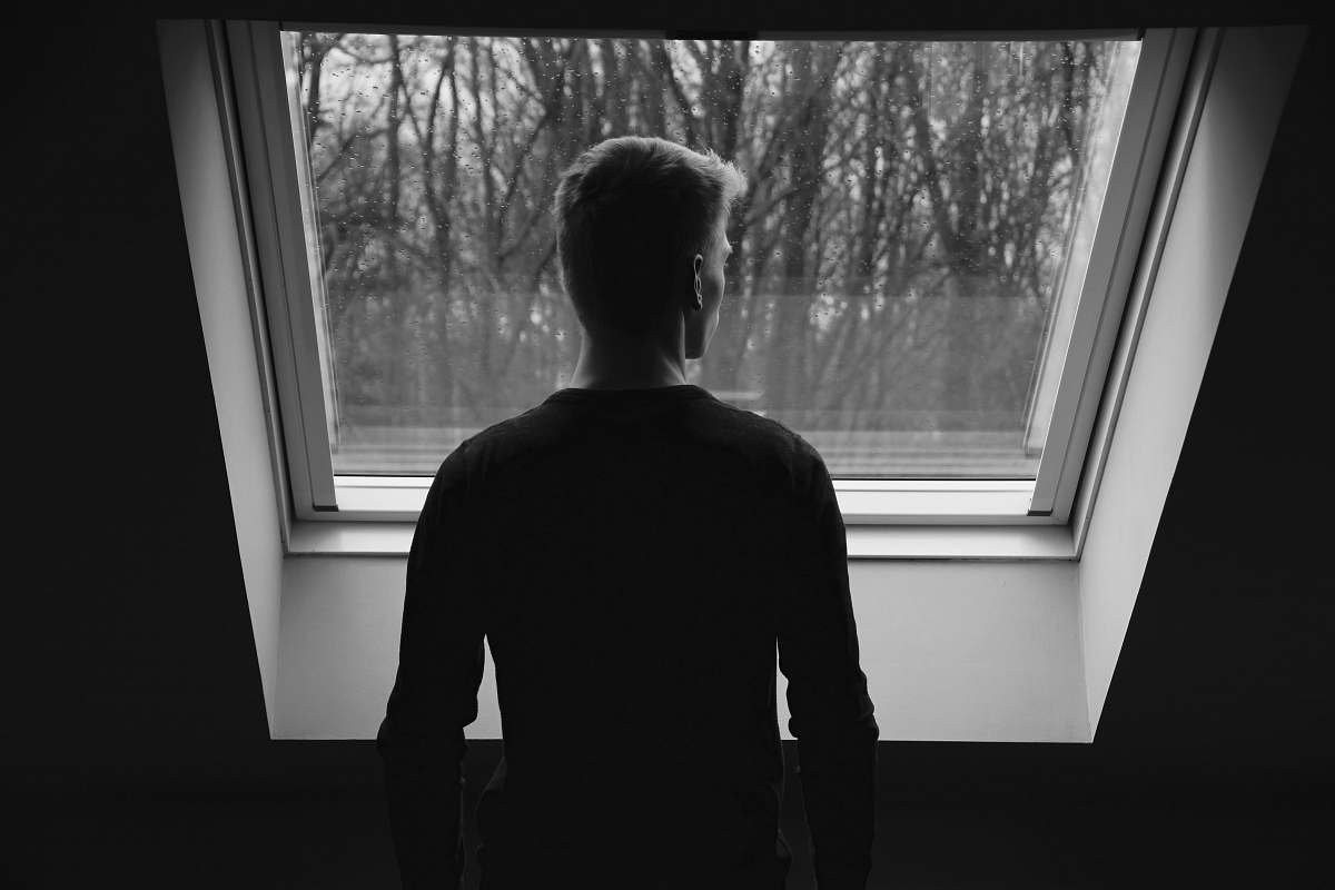 human silhouette of man looking through window black-and-white