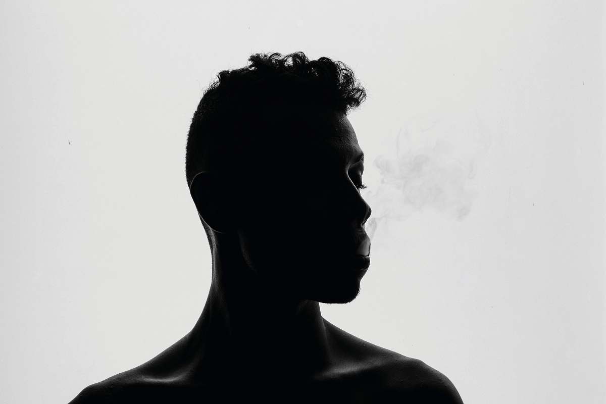 black-and-white silhouette of man smoking black