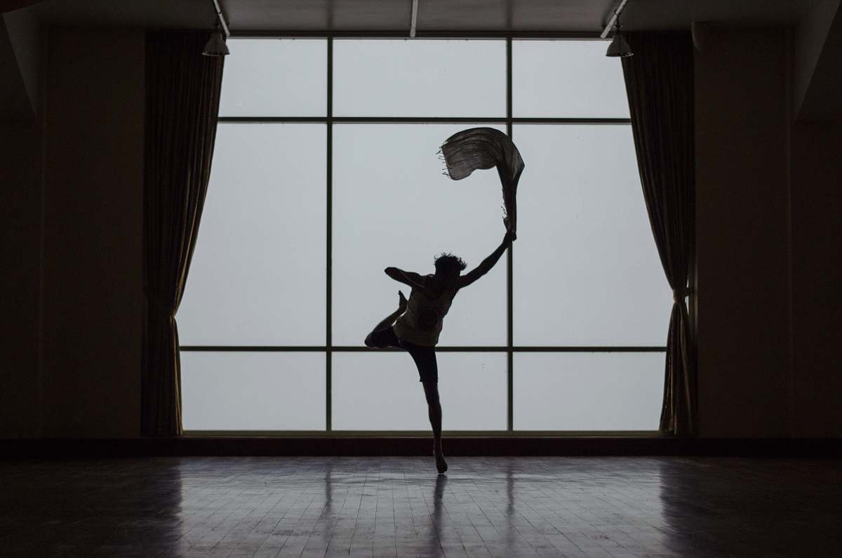grey silhouette of man standing beside window dance