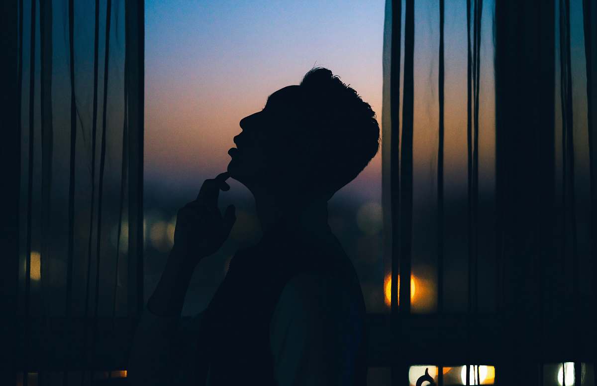 person silhouette of man standing beside window human