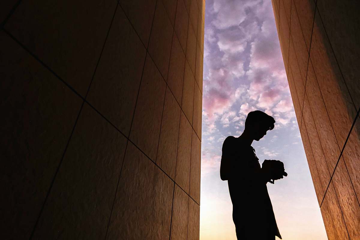 person silhouette of man standing between buildings human