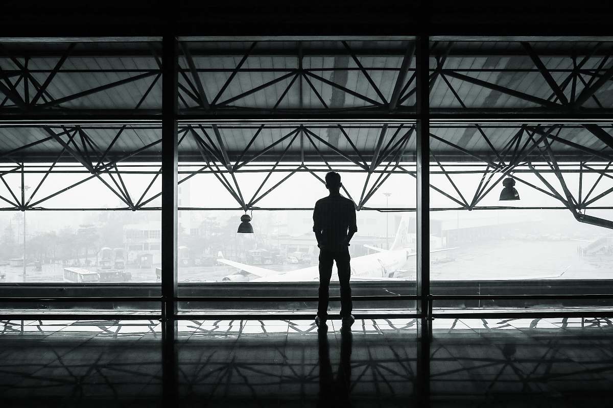 person silhouette of man standing between two posts building