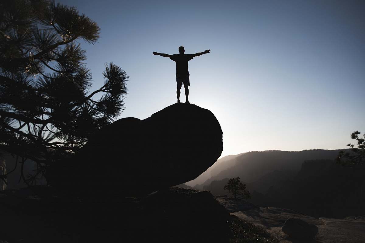 tree silhouette of man standing on boulder during daytime yosemite national park