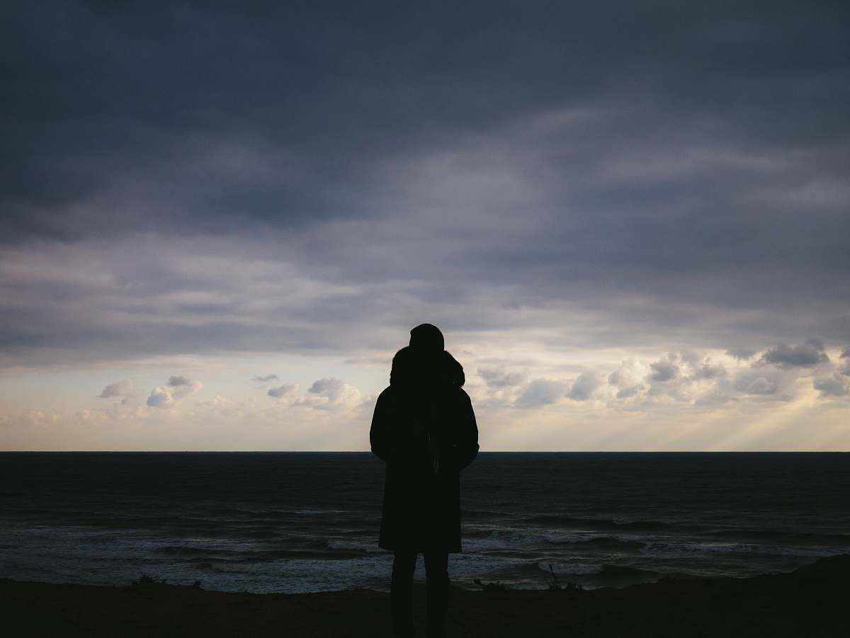 human silhouette of man standing on plains under cloudy sky during daytime person