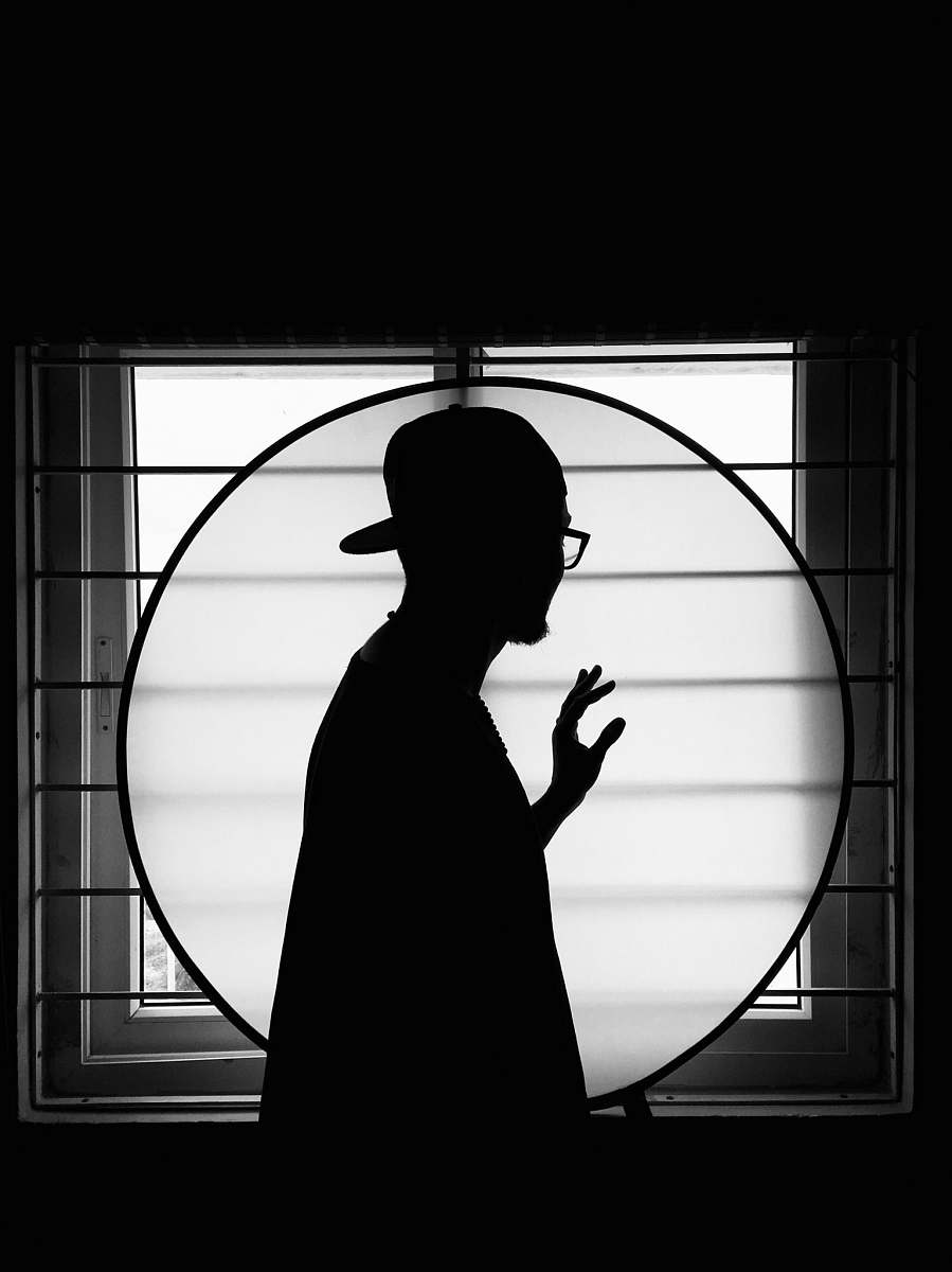 black-and-white silhouette of man standing on window person