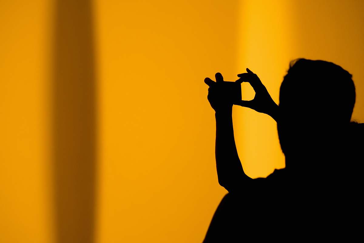 orange silhouette of man taking photo using camera the british museum