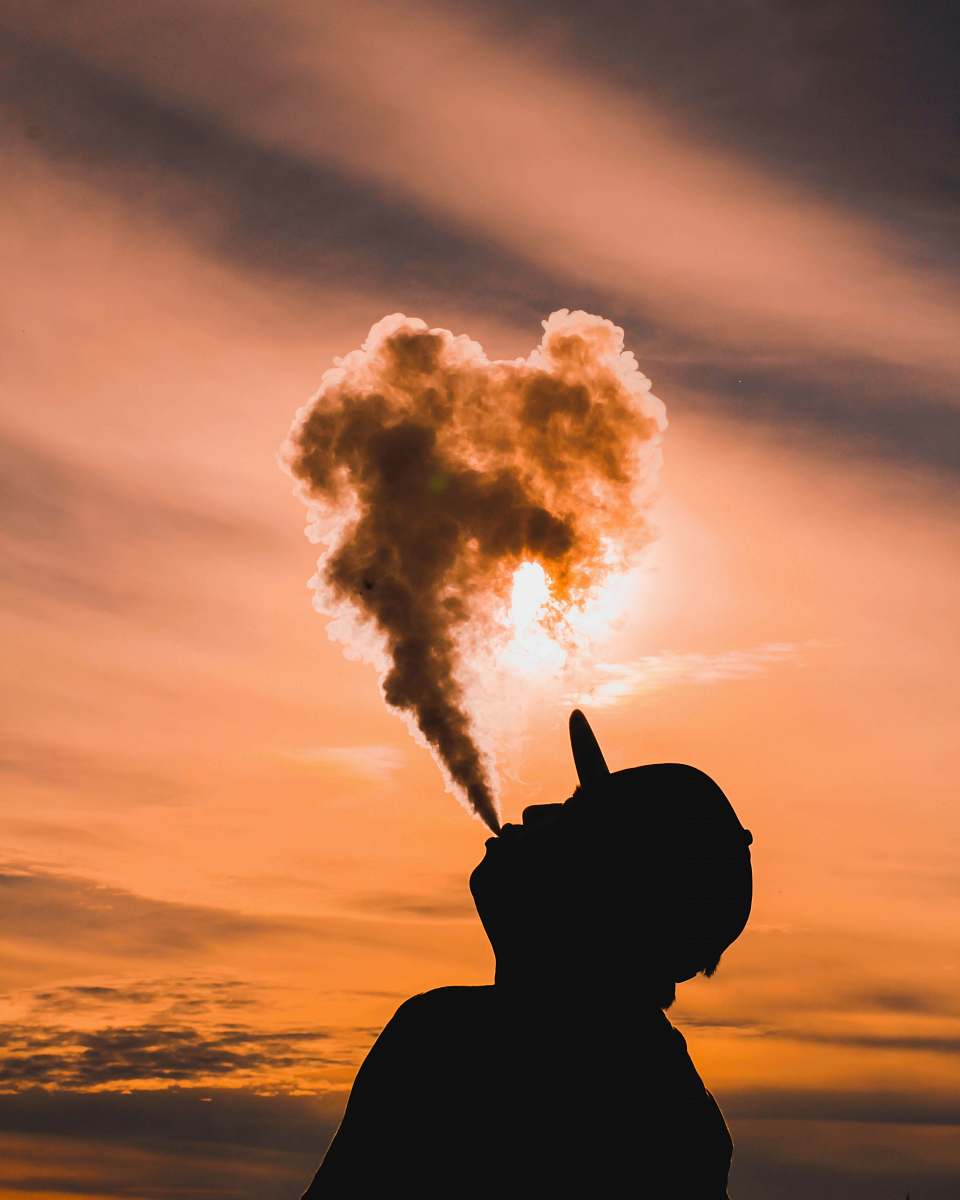 cloud silhouette of man vaping during sunset man