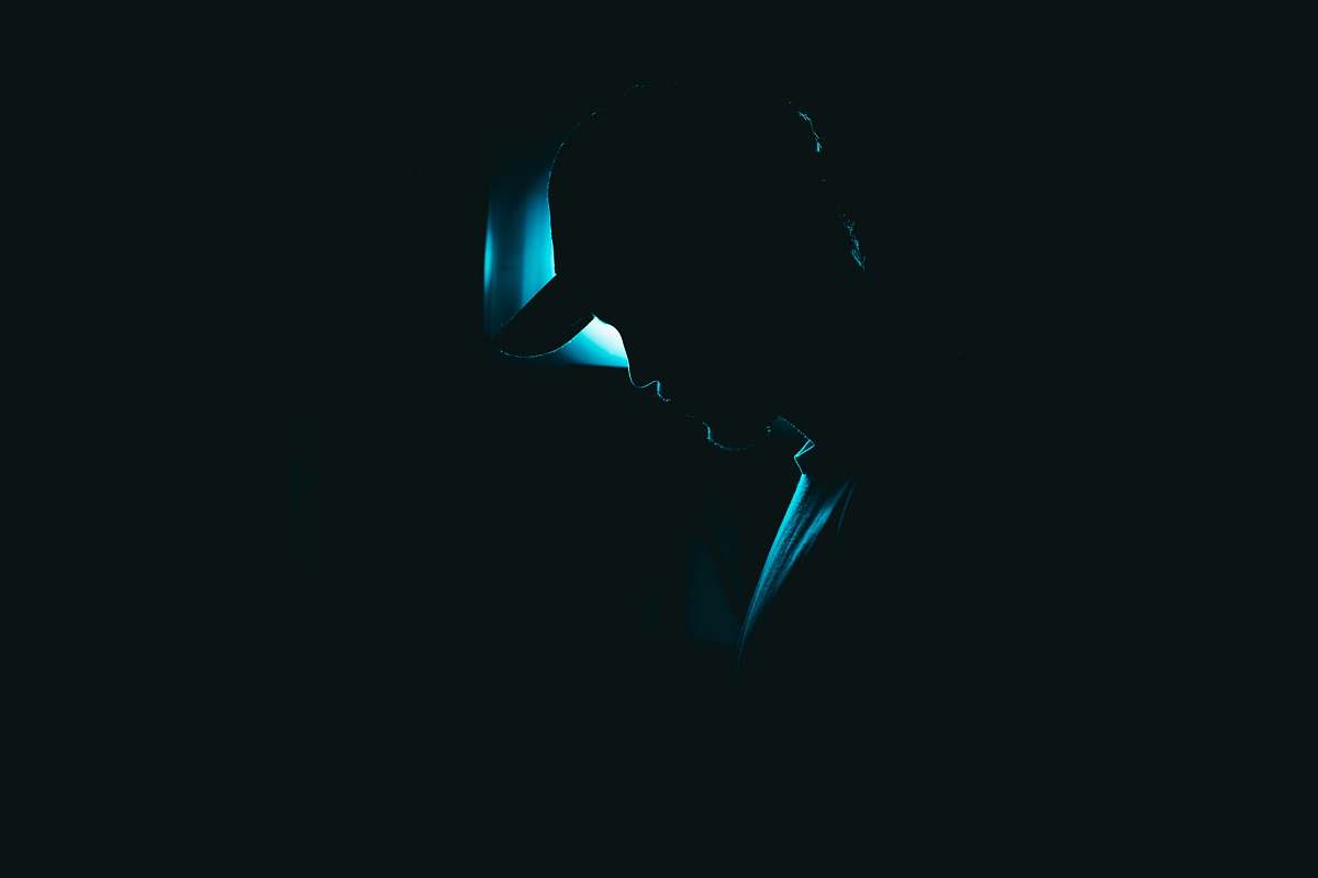 light silhouette of man wearing fitted cap lighting