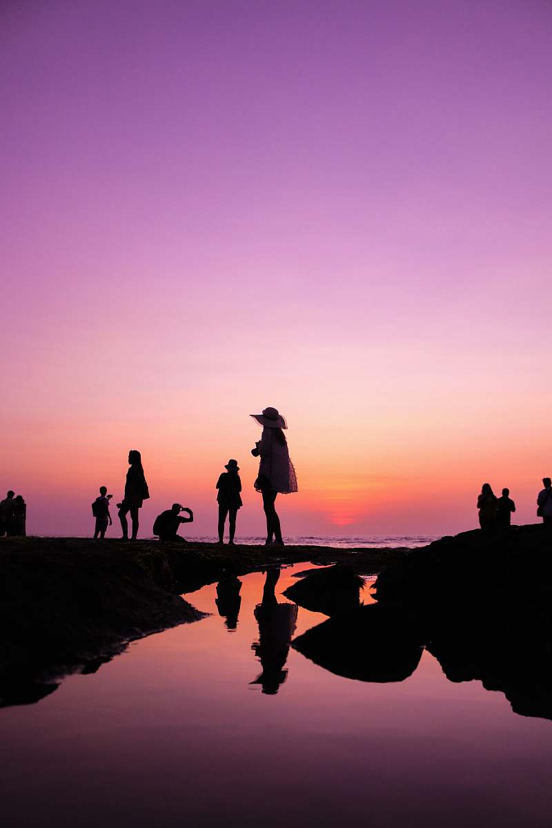 human silhouette of people at shore during golden hour person