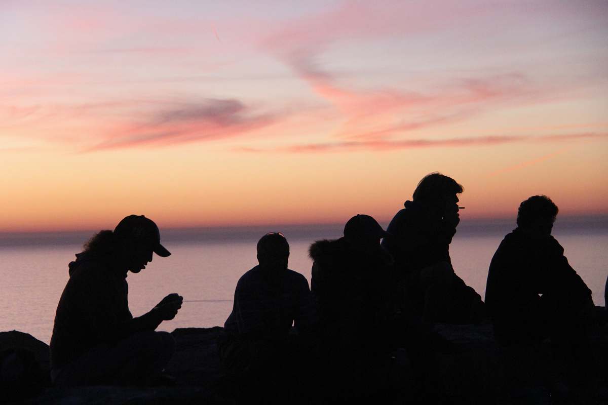 human silhouette of people sitting near body of water person