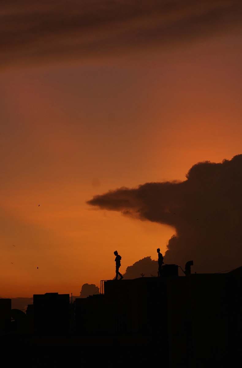 nature silhouette of people standing on rooftop outdoors