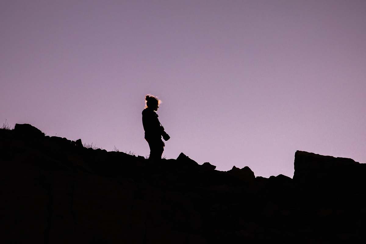 human silhouette of person holding DSLR camera person