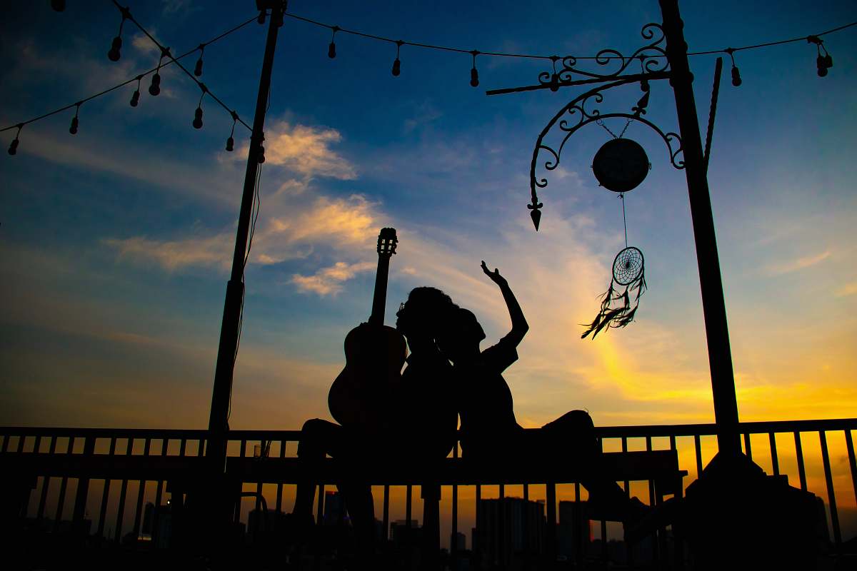 human silhouette of person holding guitar person
