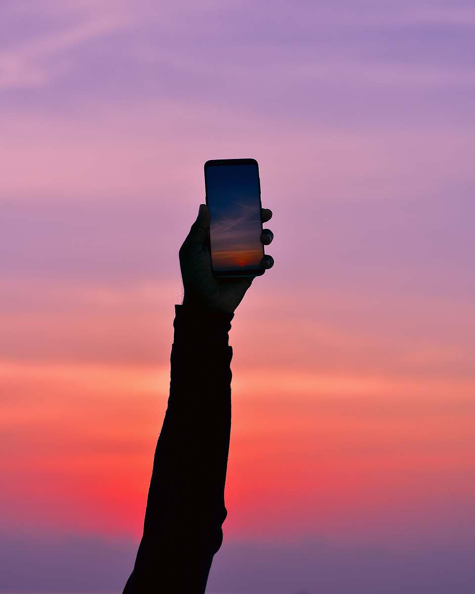 nature silhouette of person holding smartphone maldives
