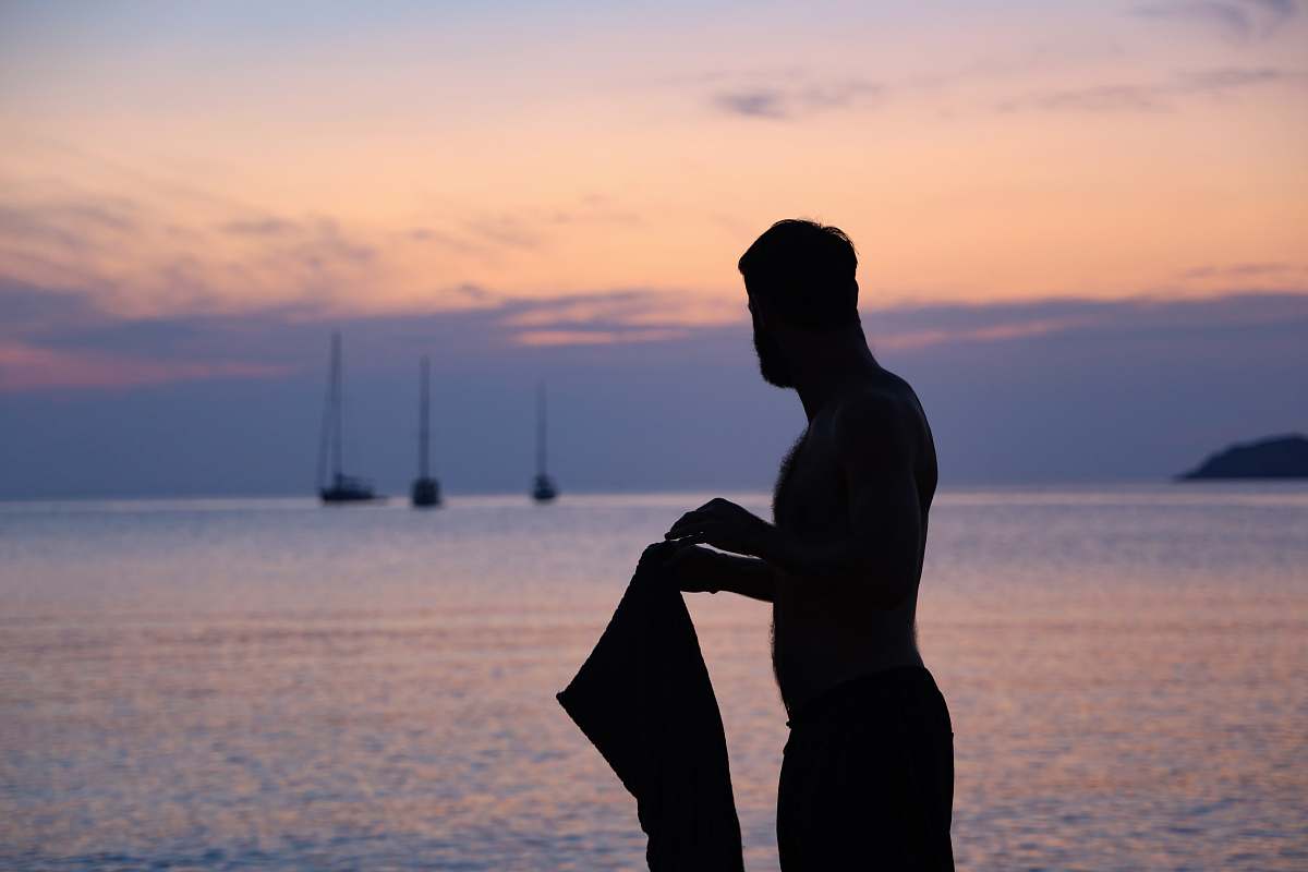 human silhouette of person holding tops boat